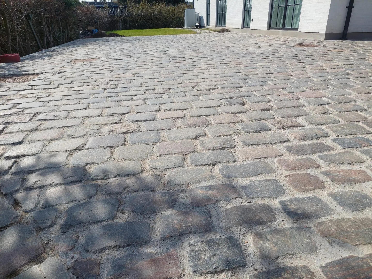 Stor indkørsel af genbrugte brosten ved hvid villa